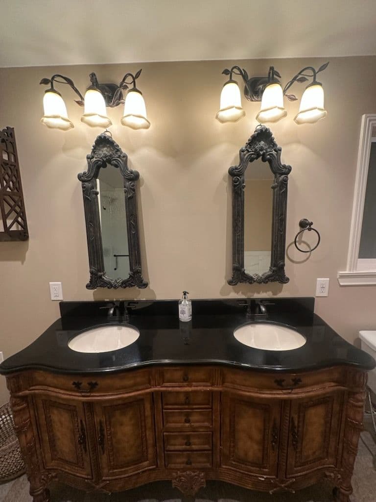 Elegant double vanity with vintage mirrors and stylish lighting in a modern bathroom.